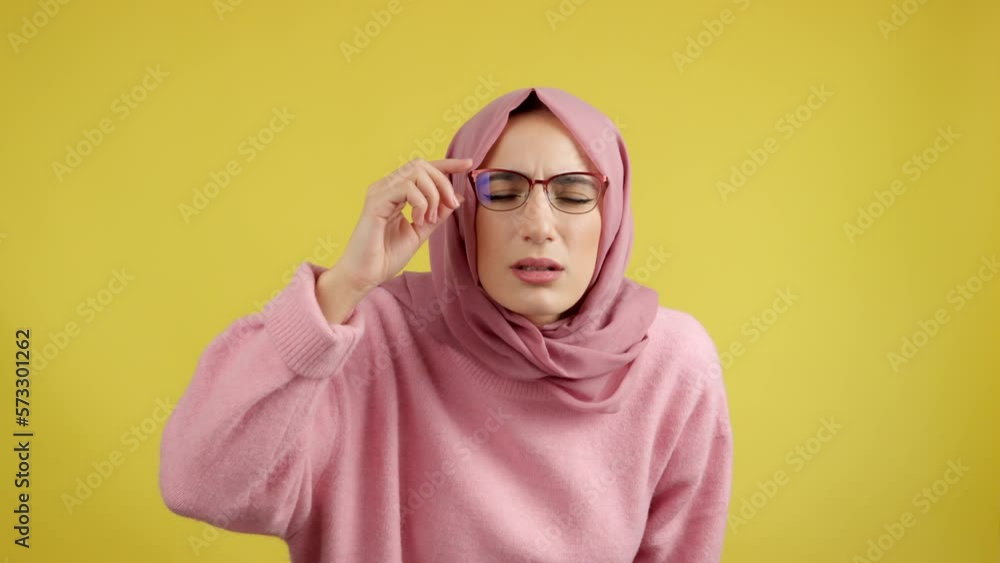 Muslim woman taking off her glasses to see Muslim woman taking off her glasses to see
