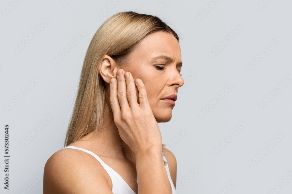 Fototapeta premium Woman having ear pain, touching her painful head, copy space