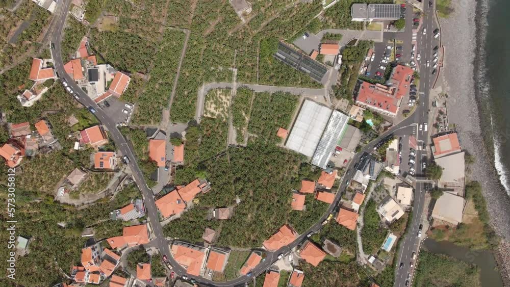 Bird's eye view of a village in Madeira Island, Portugal. Beautiful contrast between the red roofs and the banana plantations Bird's eye view of a village in Madeira Island, Portugal. Beautiful contrast between the red roofs and the banana plantations