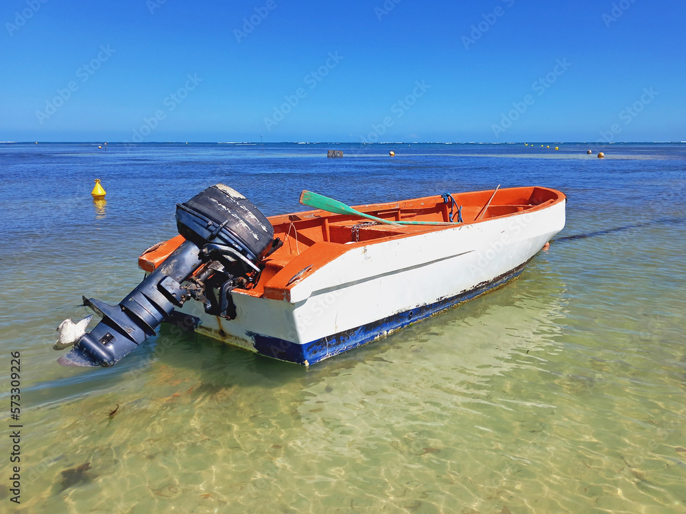 Obraz premium Old motorboat in turquoise water of the caribbean sea under tropical blue sky. Navigation, nautical and means of transport in the French Antilles.