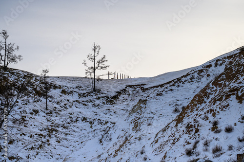 Serge on the mountain. evening light through the trees and rocks. Winter Baikal. Small sea. photo