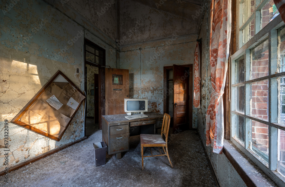Abandoned office with desk, chair, and computer