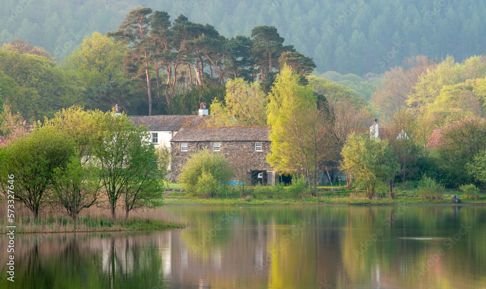 Fototapeta premium Restful image of a farmhouse on a still dawn by the lake