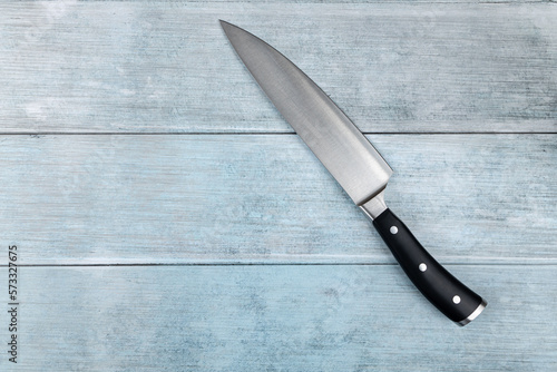 Big chef knife on the flat lay above dark blue moody background