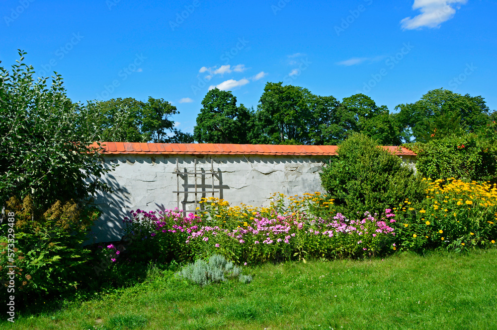 wiejski ogród, kolorowe kwiaty w ogrodzie przy kamiennym płocie, rural garden, colorful flowers in the garden by the stone wall wiejski ogród, kolorowe kwiaty w ogrodzie przy kamiennym płocie, rural garden, colorful flowers in the garden by the stone wall