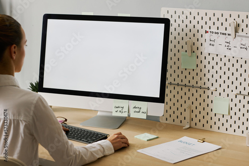 Close up young woman using computer with white screen mockup working at desk