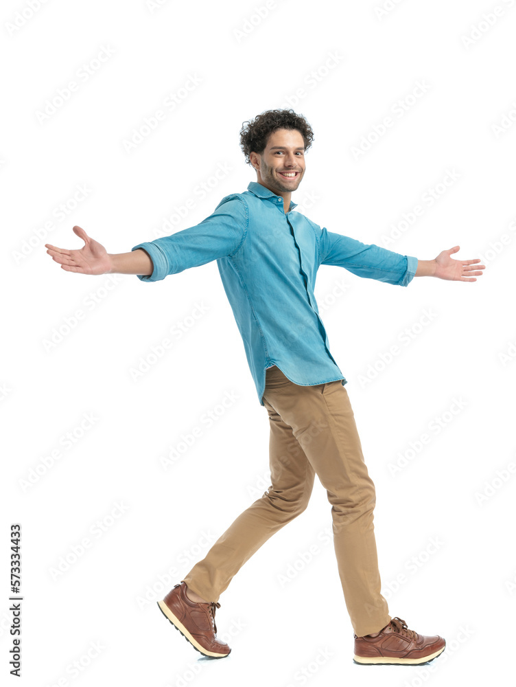 happy arab man in denim shirt opening arms, smiling and walking happy arab man in denim shirt opening arms, smiling and walking