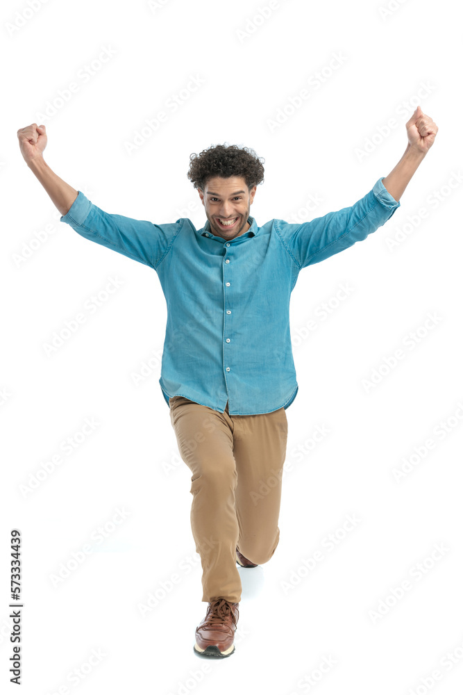 enthusiastic man with arms above head bending the knee and celebrating enthusiastic man with arms above head bending the knee and celebrating