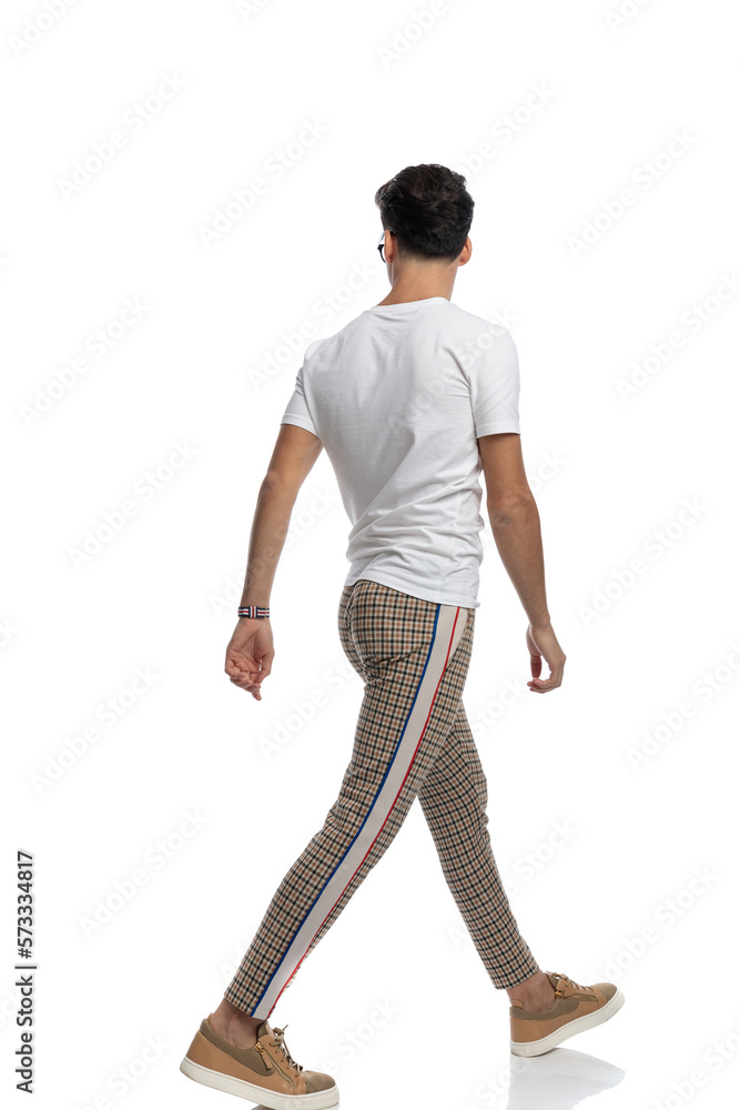 side and back view of casual guy looking away and walking