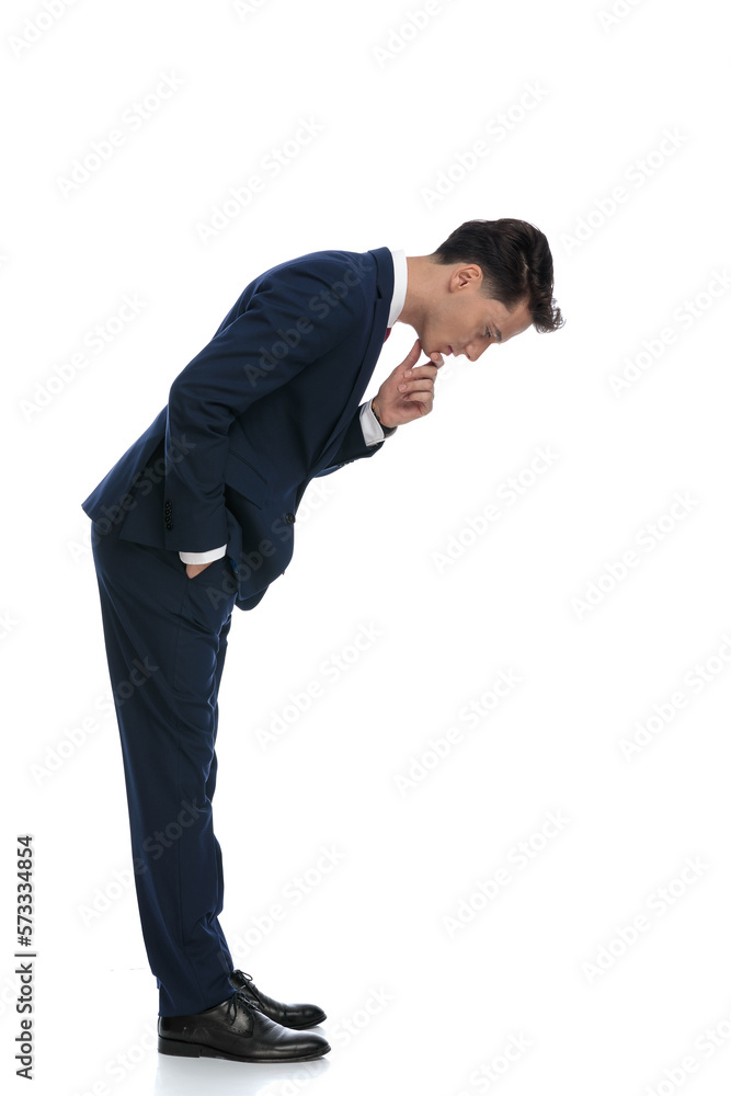 businessman looking down and scratching his chin businessman looking down and scratching his chin