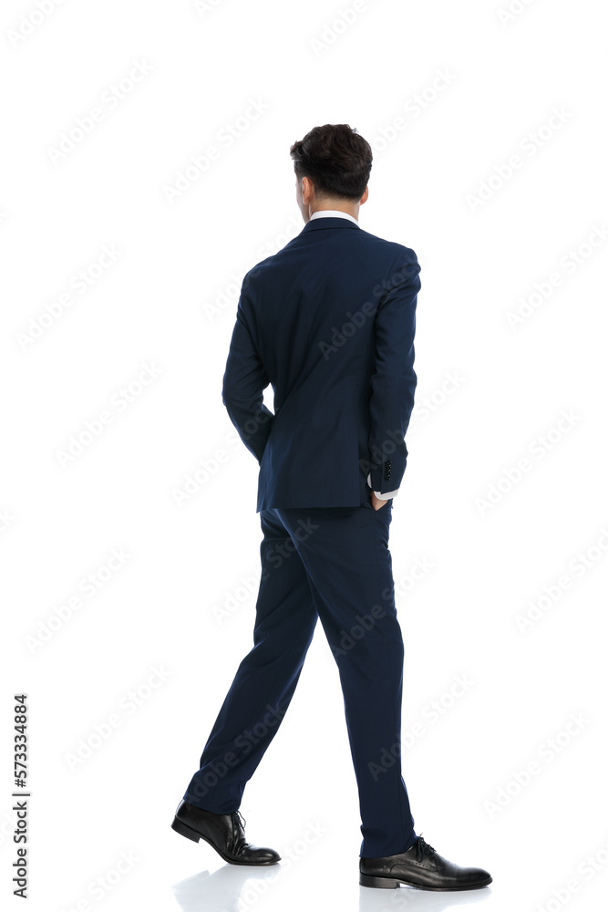 businessman walking with hands in pockets and looking away businessman walking with hands in pockets and looking away