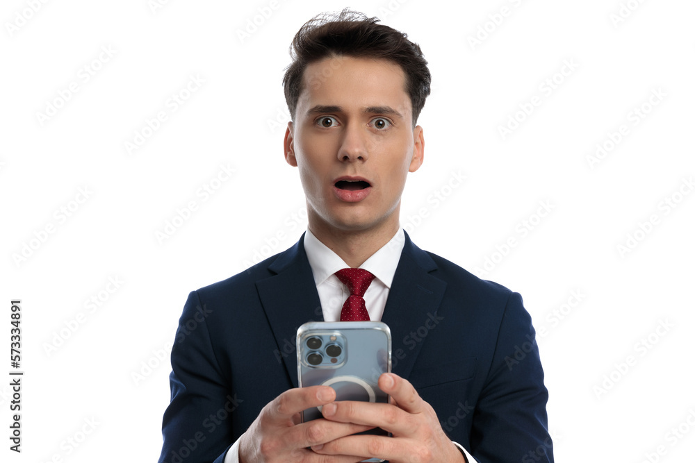 businessman texting on his phone and feeling shocked businessman texting on his phone and feeling shocked