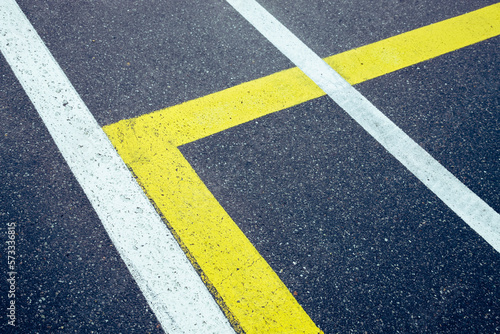 Beutiful street background with white and yellow lines. Street with rough surface, no person © YK
