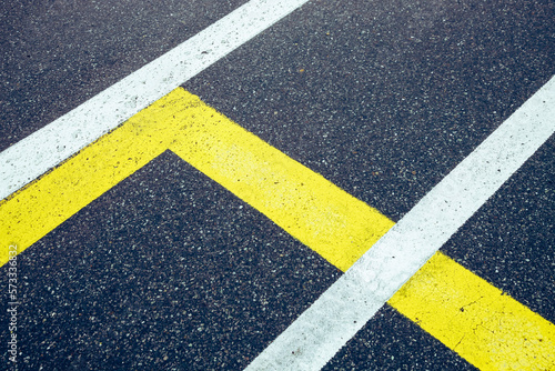 Beutiful asphalt background with white and yellow lines. Street with rough surface, no person © YK