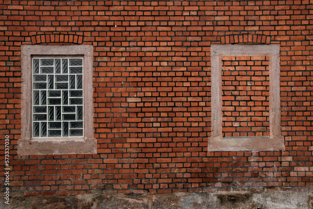 Fototapeta premium brick wall with an glas window and an bricked up window