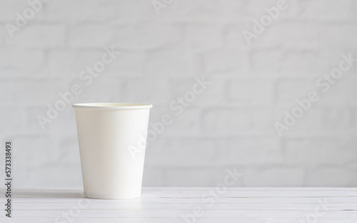 White paper cup on the background of the wall. Eco-friendly tableware. Template, copy space. Zero waste concept