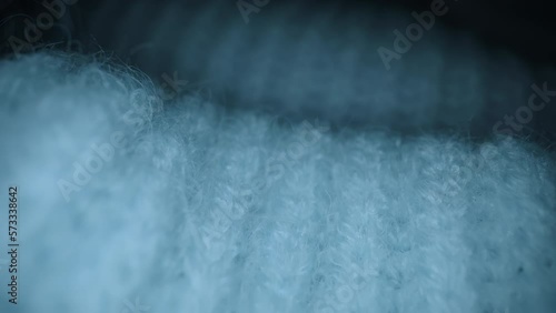 Macro shot of woolen fabric, knitted wool pullover. Slider dolly extreme close-up of clothing material blue woollens, woolens, wool fibers. Camera glides over warm winter clothing fabric texture