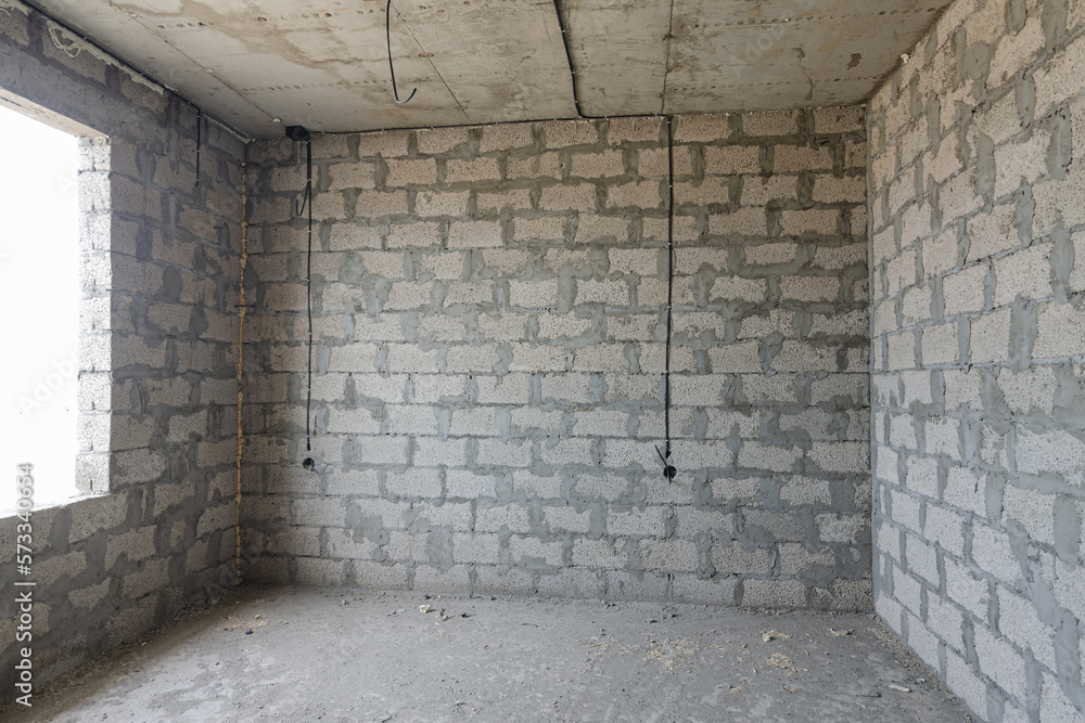 Construction of an individual residential building, a view of the expanded clay concrete wall without finishing, electric wires are laid Construction of an individual residential building, a view of the expanded clay concrete wall without finishing, electric wires are laid