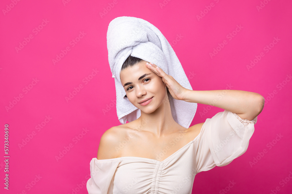 Portrait of young beautiful woman after bath. Beauty face of a cheerful attractive girl with towel on head against a pink background. Portrait of young beautiful woman after bath. Beauty face of a cheerful attractive girl with towel on head against a pink background.