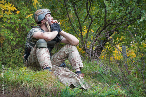 Sad soldier sits on the ground