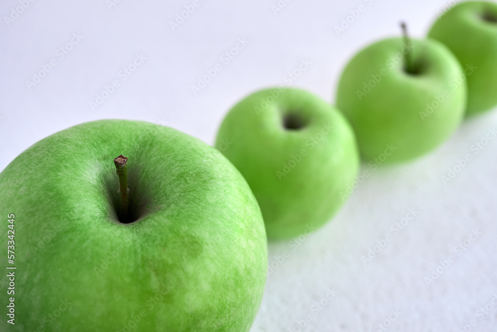 Green apples on a white background in a row diagonally. Apples in the snow. Green apples on a white background in a row diagonally. Apples in the snow.