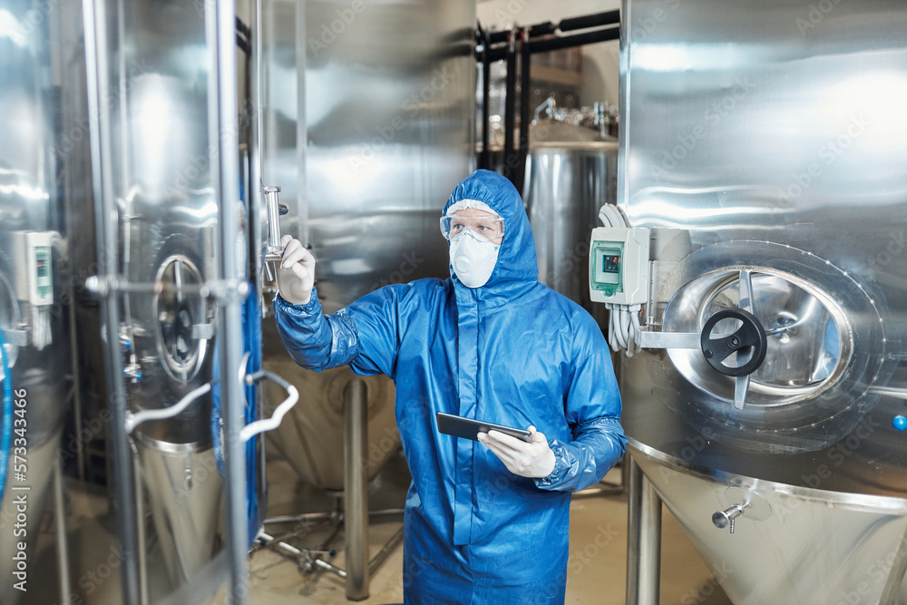 Male worker wearing protective gear overseeing production Male worker wearing protective gear overseeing production