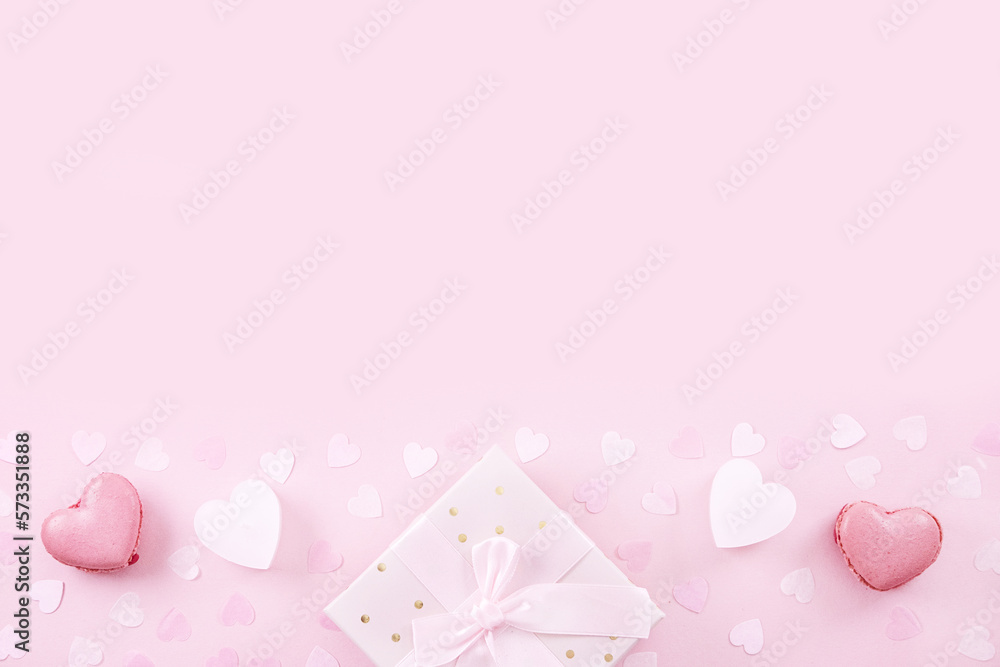 Gift or present box macaron or macaroon confetti on pink background top view.