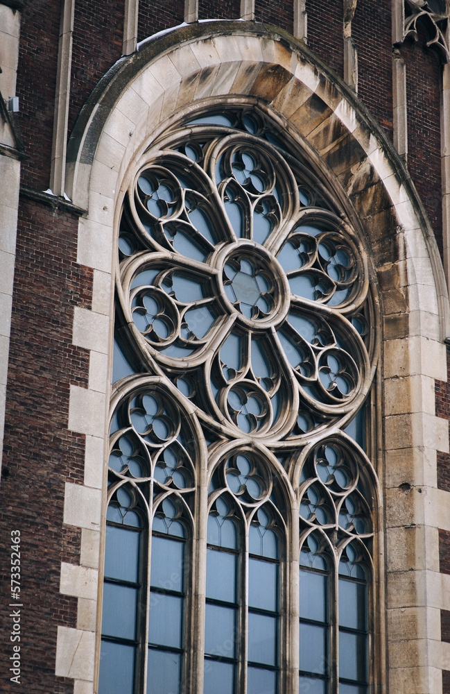 Openwork large round window with stained glass on facade of the building. Baroque and Gothic architecture. Church of Saint Olga and Elizabeth. Lviv, Ukraine.