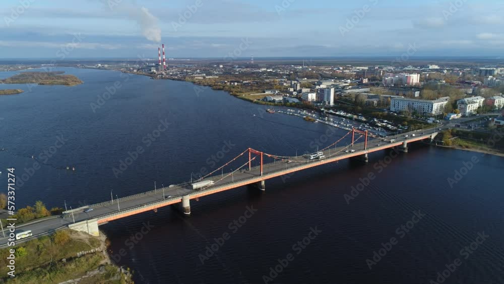 Aerial view. Cars are moving on a road bridge across the river in Arkhangelsk at sunny summer day. Aerial view. Cars are moving on a road bridge across the river in Arkhangelsk at sunny summer day.