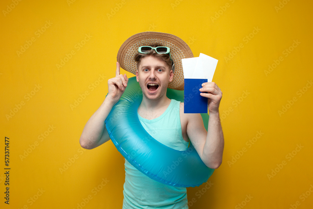 guy in the summer on vacation with a passport and tickets shows a thumbs up on a yellow background, I have an idea guy in the summer on vacation with a passport and tickets shows a thumbs up on a yellow background, I have an idea