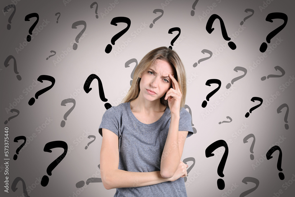 Amnesia concept. Woman trying to remember something. Question marks on color background symbolizing memory loss Amnesia concept. Woman trying to remember something. Question marks on color background symbolizing memory loss