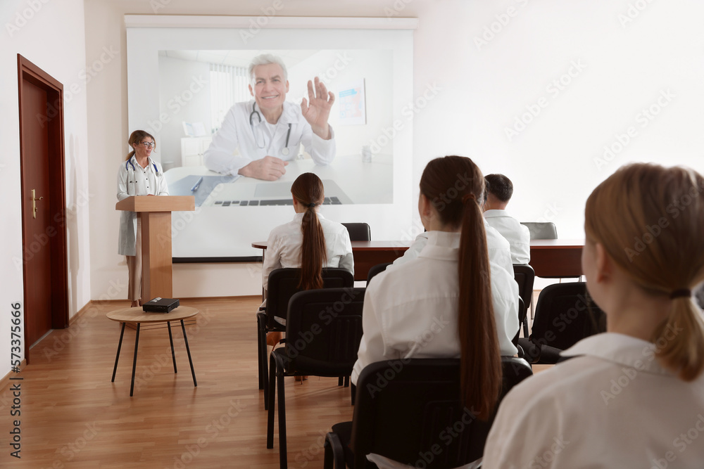 Lecture with online participant. Doctors in meeting room. Using projector for videoconference