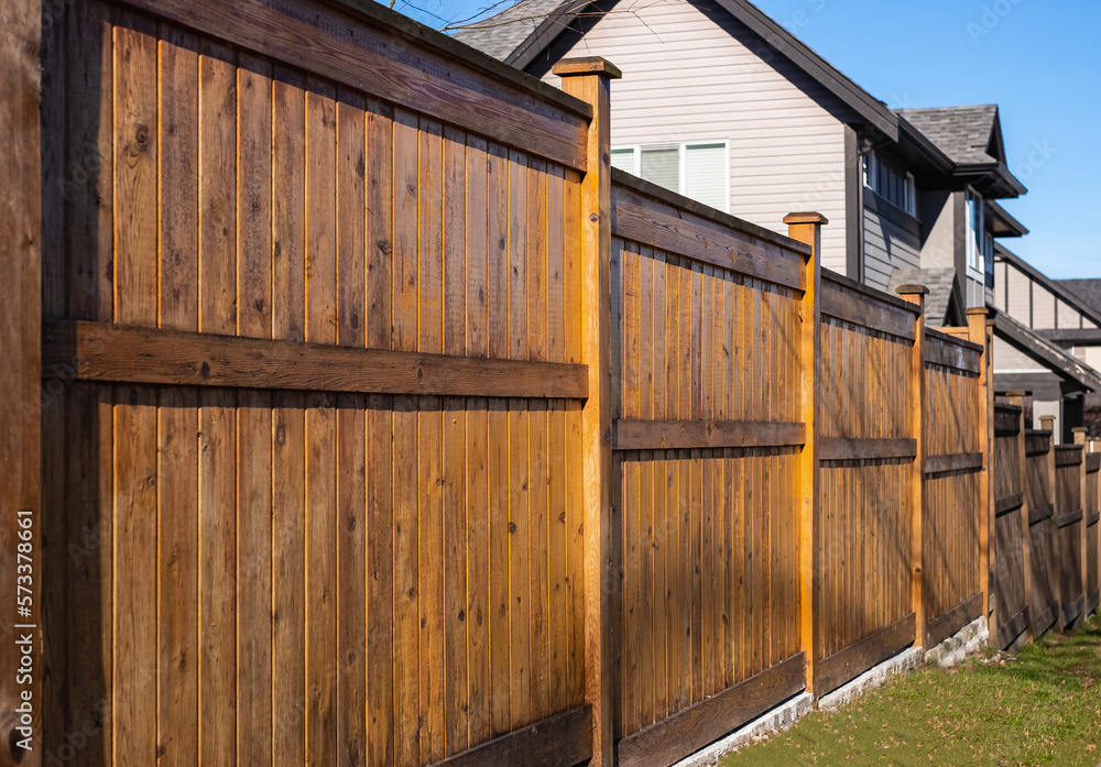 Nice wooden fence around house. Wooden fence with green lawn. Street photo Nice wooden fence around house. Wooden fence with green lawn. Street photo