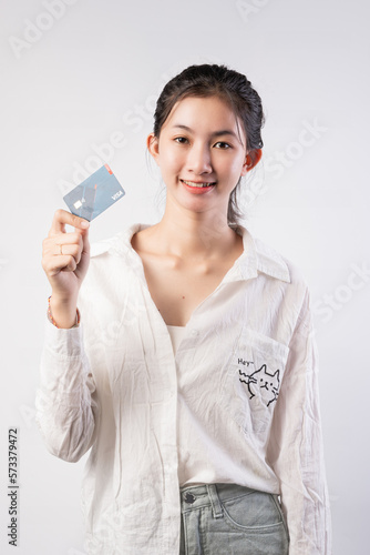 Young beautiful Asian woman smiling  showing  presenting credit card for making payment or paying online business  Pay a merchant or as a cash advance for goods  Cardholder or A person who owns a card