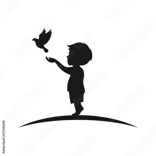 silhouette of boy releasing bird from his hands happily