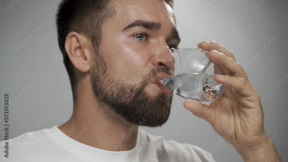 Man taking fish oil capsule with water in front of camera. Man taking fish oil capsule with water in front of camera.