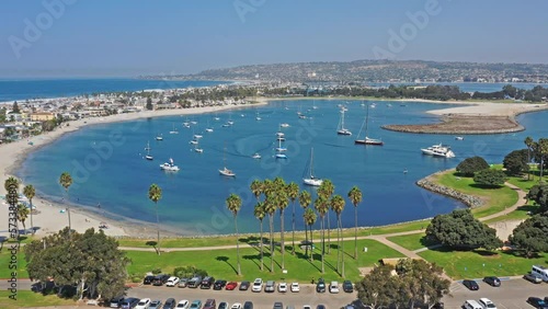 Drone shot in San Diego Bay of sail boats ancored with one small moror boat hooking up to large sail boat in California. photo