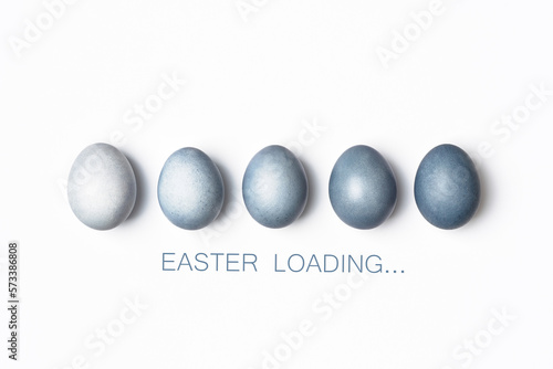 Fototapeta Naklejka Na Ścianę i Meble -  Dyed blue gradient Easter eggs row on white. Easter loading concept. Creative greeting card, minimal.