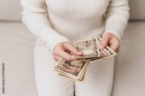 Woman hand holding Japanese Yen banknote stack. Thousand Yen money. Japan cash, Tax, Recession Economy, Inflation, Investment, finance and shopping payment concepts