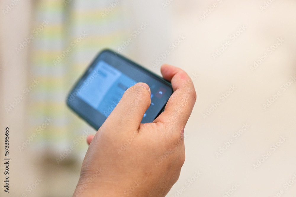 Close up of woman hands using smartphone in mall outdoor, typing text message on cellphone.shopping mall Close up of woman hands using smartphone in mall outdoor, typing text message on cellphone.shopping mall