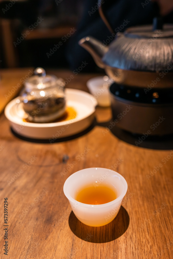 Cup of Chinese tea and teapot on a wooden table close-up view Cup of Chinese tea and teapot on a wooden table close-up view