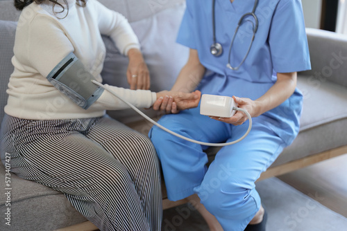 Portrait of female doctor measuring patient's blood pressure before treatment. © Jirapong