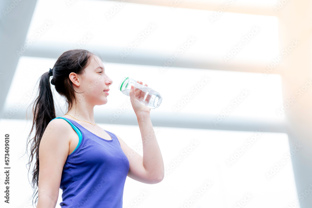 Women drinking water bottle running exercise in modern city wear wellness sportswear outside. Young woman workout outdoor exercising on bright sunny outside. Healthy wellness lifestyle woman concept Women drinking water bottle running exercise in modern city wear wellness sportswear outside. Young woman workout outdoor exercising on bright sunny outside. Healthy wellness lifestyle woman concept