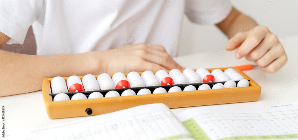The boy is engaged in abacus, mental arithmetic for children The boy is engaged in abacus, mental arithmetic for children