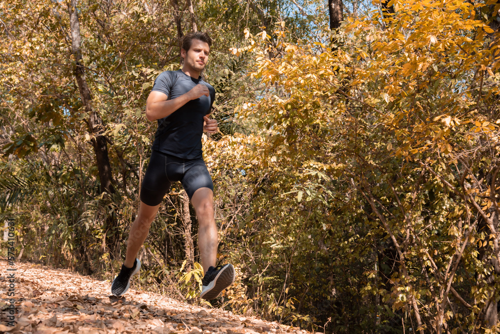 Marathon runner exercising in sportswear training for running competition or triathlete, sprinting workout in trail mountain countryside, athlete in sports shoe jogging challenge running lifestyle Marathon runner exercising in sportswear training for running competition or triathlete, sprinting workout in trail mountain countryside, athlete in sports shoe jogging challenge running lifestyle