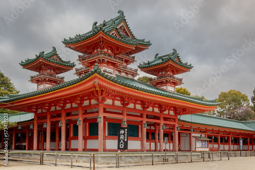 Colorful orange Buddhist temple structure pagoda building at the Heian Shrine in Kyoto Japan on a cloudy sky day