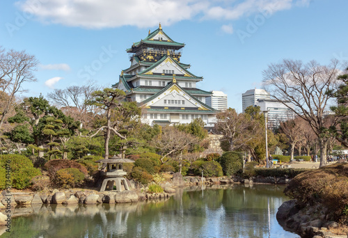 Green and white traditional Japanese architecture building and garden park and trees of the Osaka Castle in Osaka Japan
