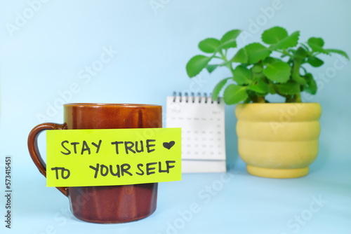 Stay true to yourself self honesty message concept. Selective focus of a cup of coffee with handwritten bright paper message note.