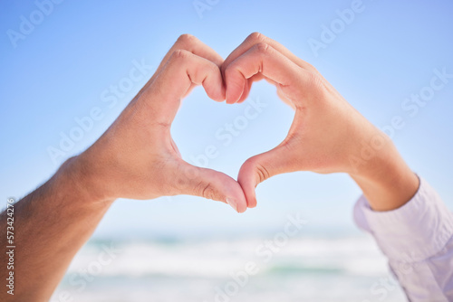 Love, hands or couple at beach with heart sign on holiday vacation or romantic honeymoon to celebrate marriage Commitment, trust or lovers showing hearty shape emoji or icon in fun summer romance © Nadia L/peopleimages.com