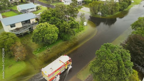 Fire truck driving through flood waters after Cyclone Gabrielle rips through New Zealand. Drone footage of road under water.